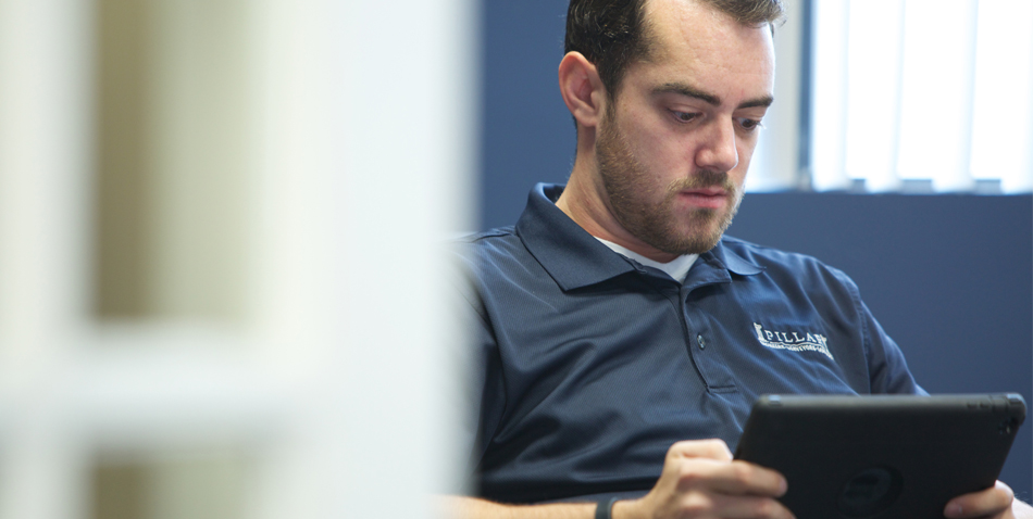 Pillar Employee Analyzing Data on Tablet