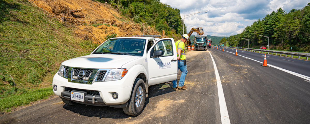 man and truck on side of highway